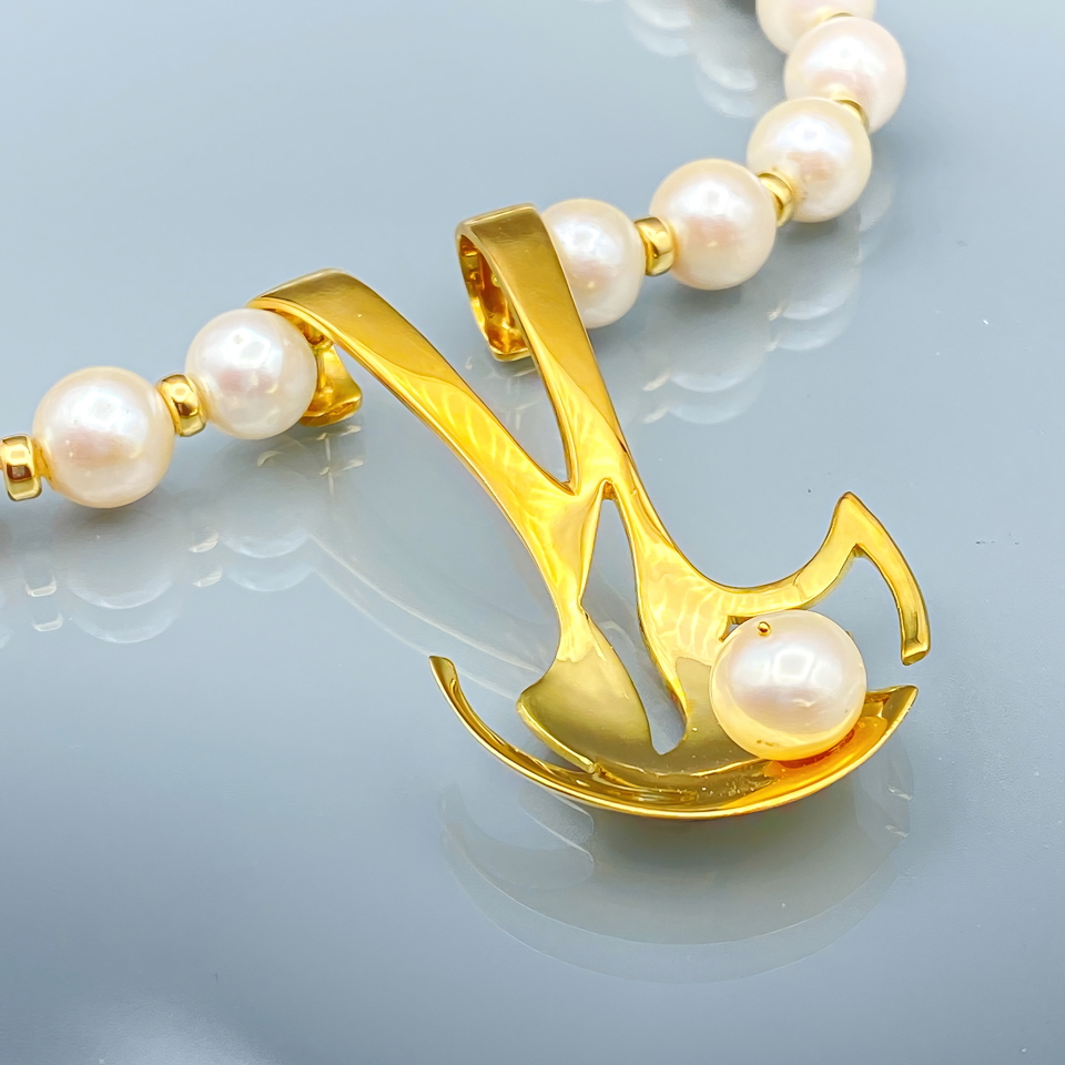 La découverte  Pendentif or jaune 750 monté sur un superbe collier de perles blanches et rondes de 11mm